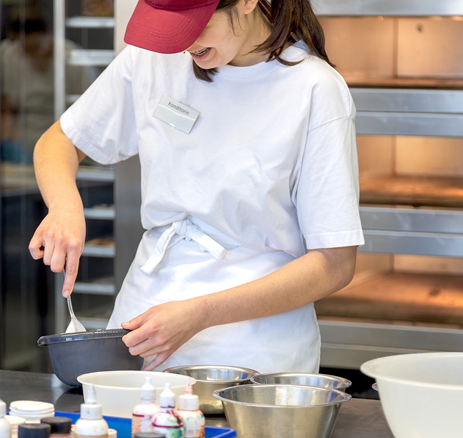 Bäckerin in Ausbildung bereitet Teig in der Backstube vor