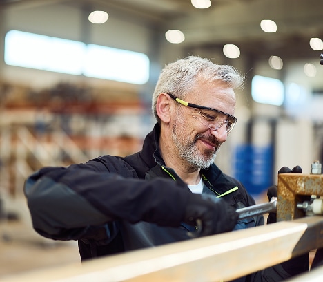 Erfahrener Handwerker bei der Holzverarbeitung in einer modernen Werkstatt