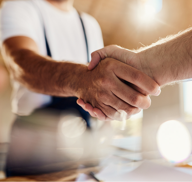 Handschlag zwischen zwei Personen als Symbol für partnerschaftliche Zusammenarbeit im Handwerk